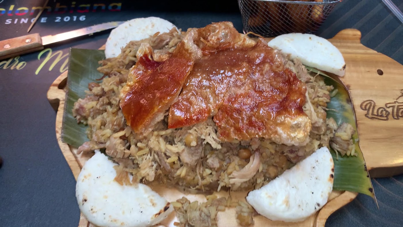 Lechón platter with rice, beans and arepa